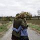 Mother and daughter hugging on dirt road, Lakefield, Ontario, Canada